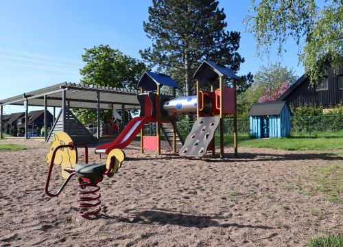 Gunghäst på fjädrar med klätterställning i bakgrunden