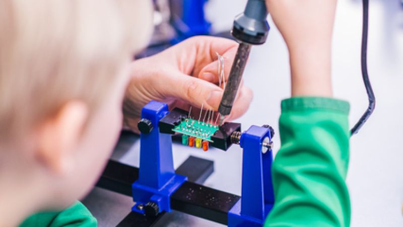 Pojke som löder på lödkolv