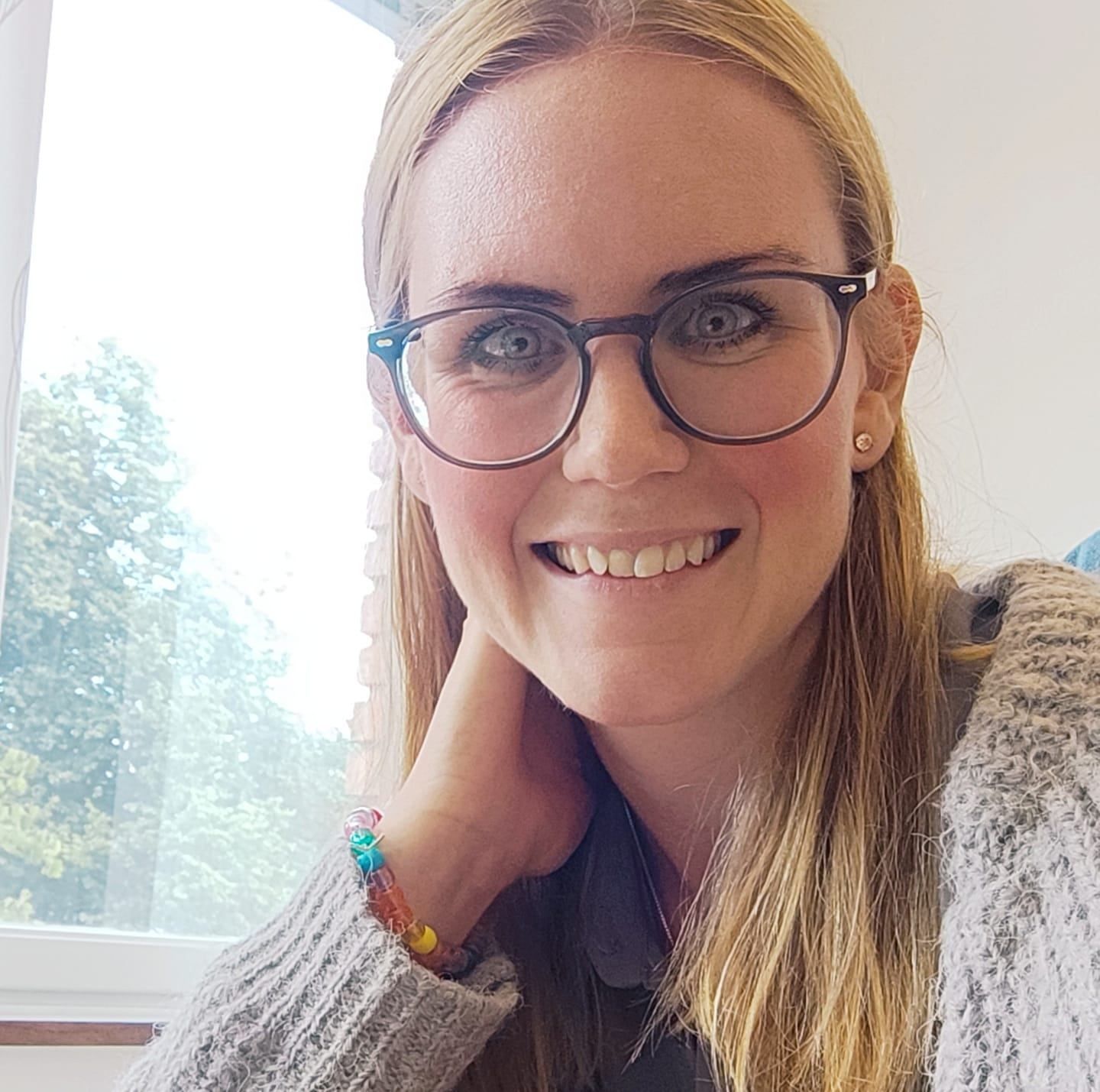 Hanna Sandberg, kvinna i glasögon och långt hår lutar armen mot ett ståbord.