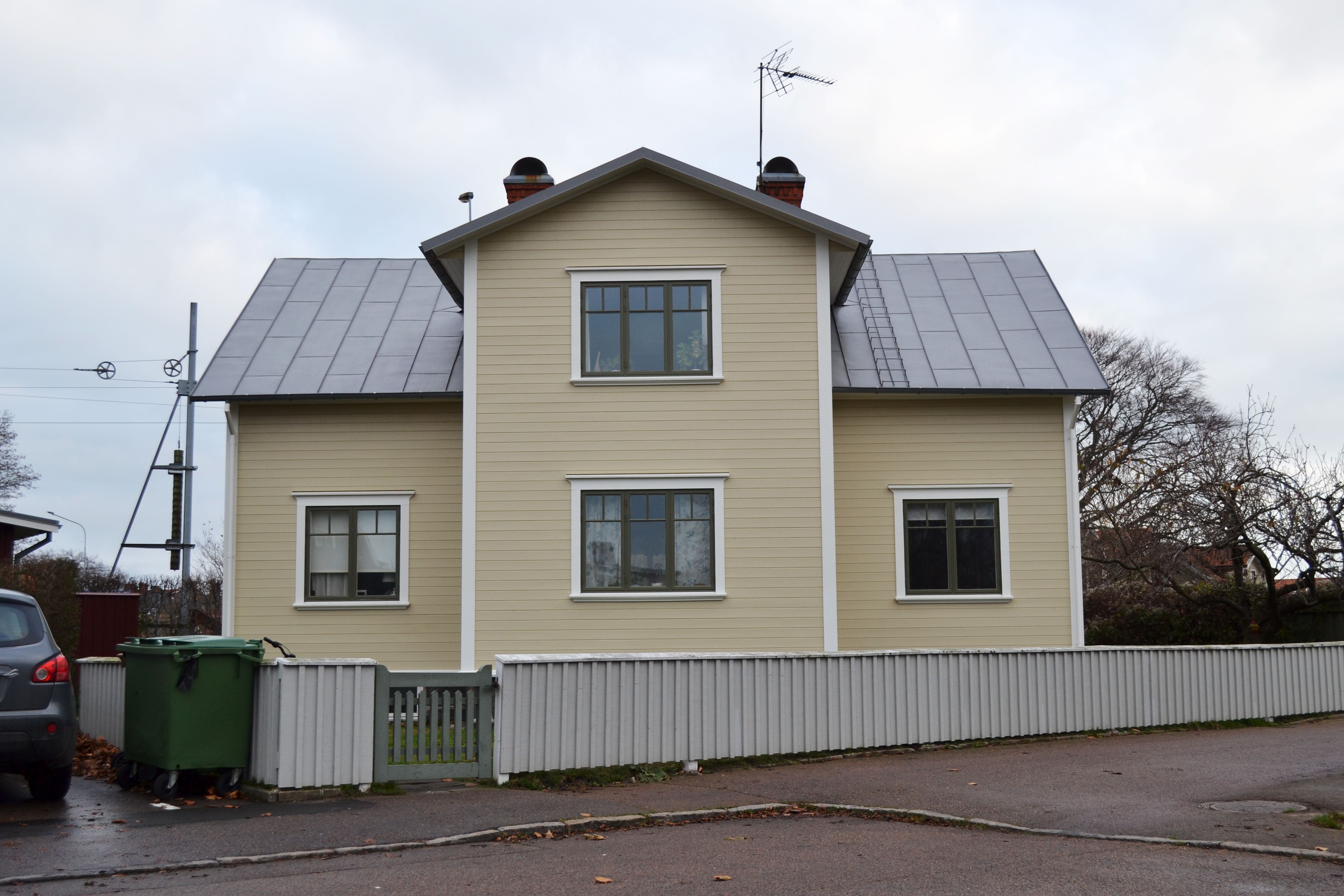 Ett ljusgult hus med svart tak.