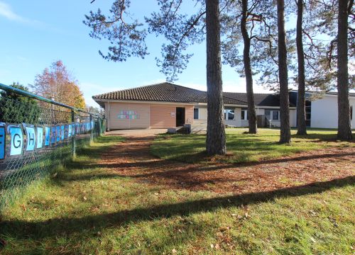 Gård med gräs och träd, alfabetet uppsatt på staketet