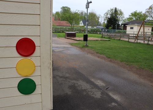 Vit fasad med trafikljus bredvid asfaltsväg