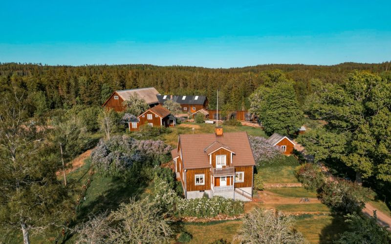 Blå himmel och röda hus, ett med takkupa synlig.