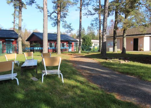 Stolar utplacerade i gräset på gården