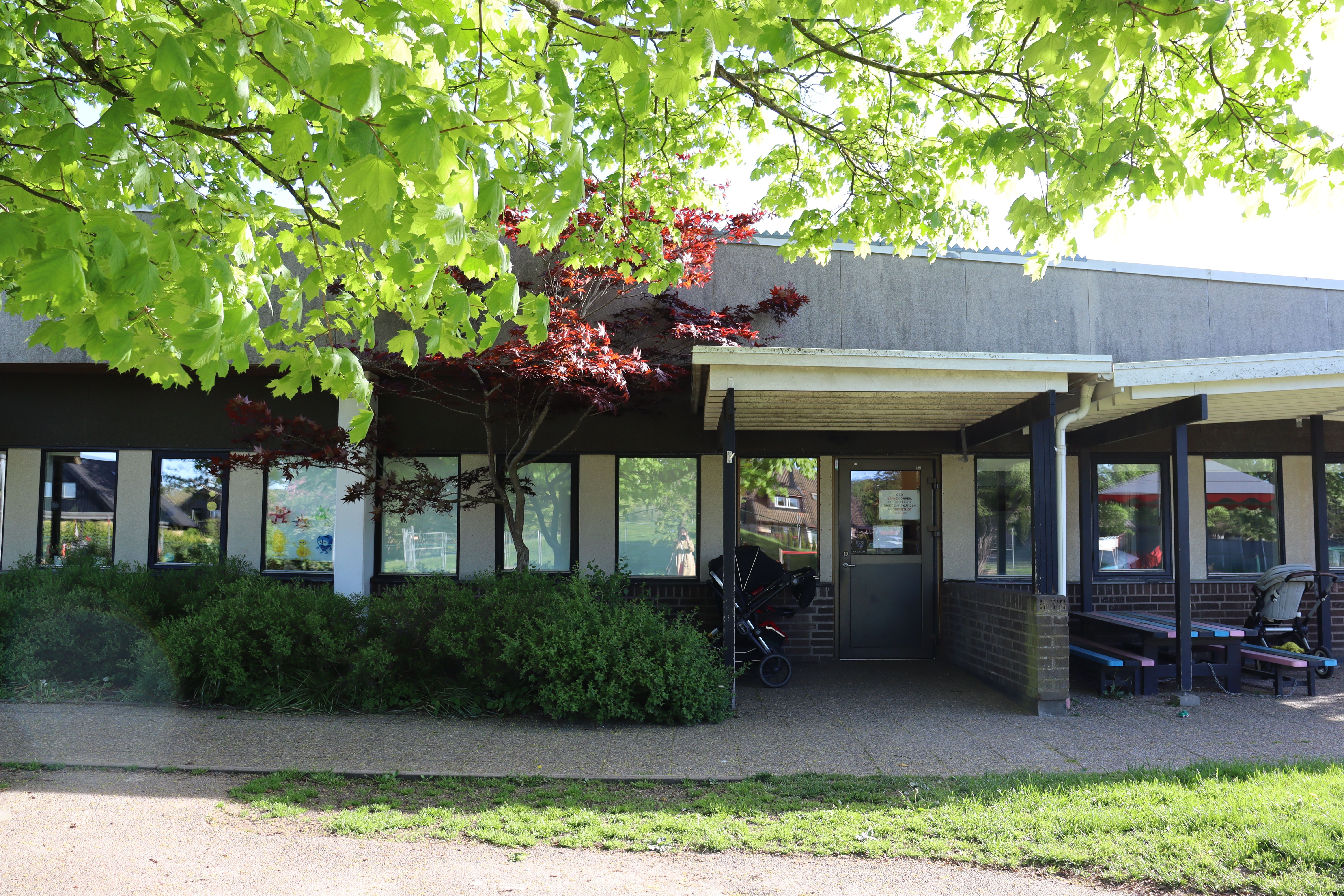 Låg byggnad med brun och vit fasad med många fönster