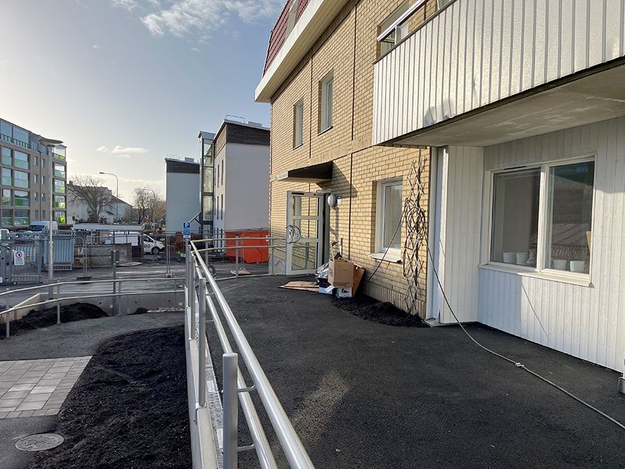 Gul tegelbyggnad med räcke framför.