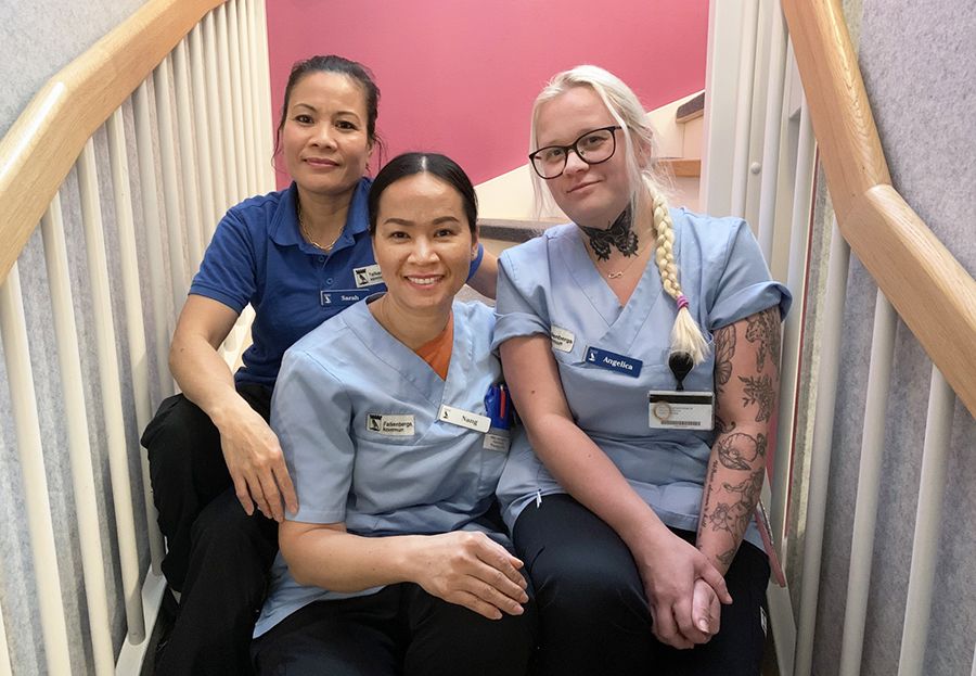 Tre kvinnor sitter bredvid varandra i en trappa.