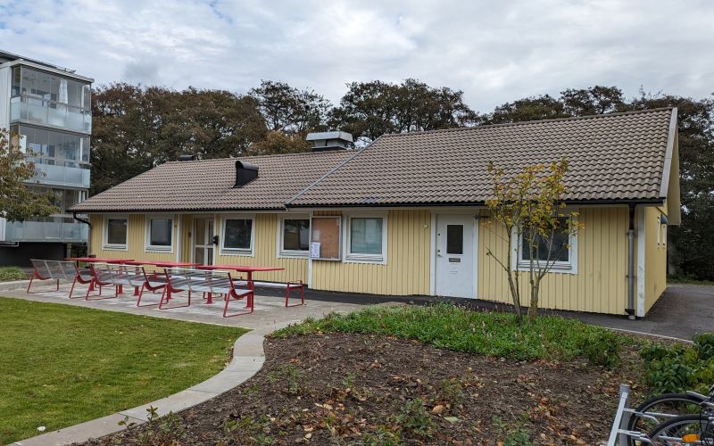 En gul byggnad med lägenheter i bakgrunden.