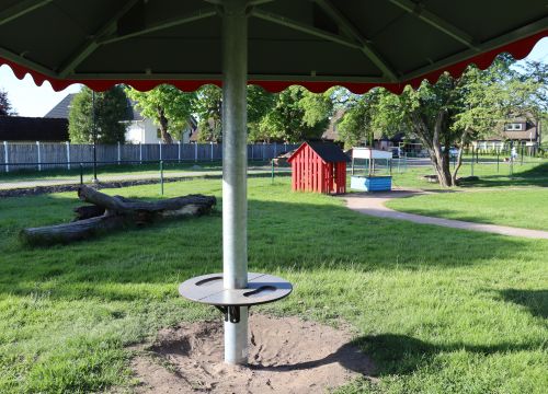 Parasoll med stock och röd stuga i bakgrunden