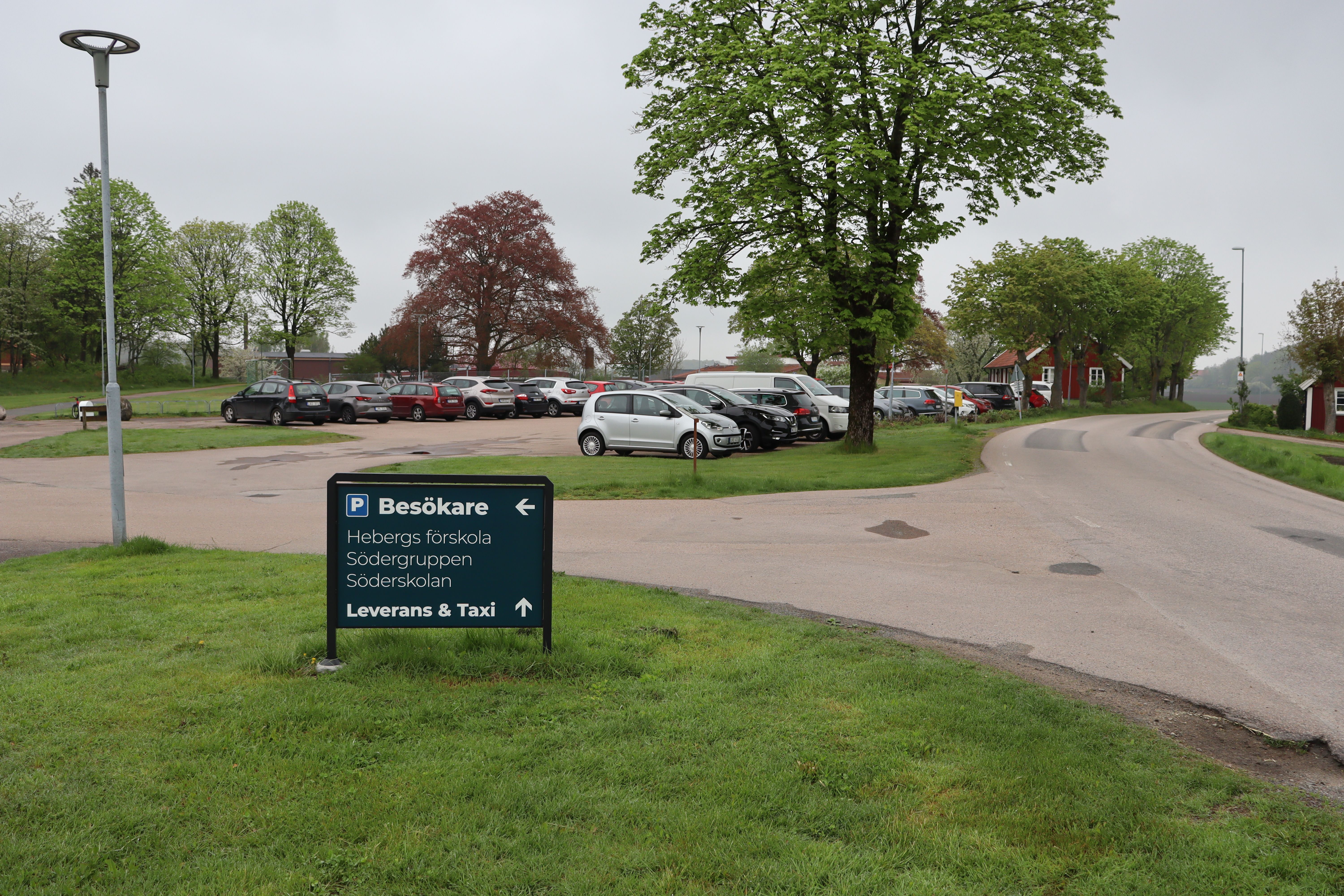 Skylt vid väg för besökare till förskolan - parkering i bakgrunden