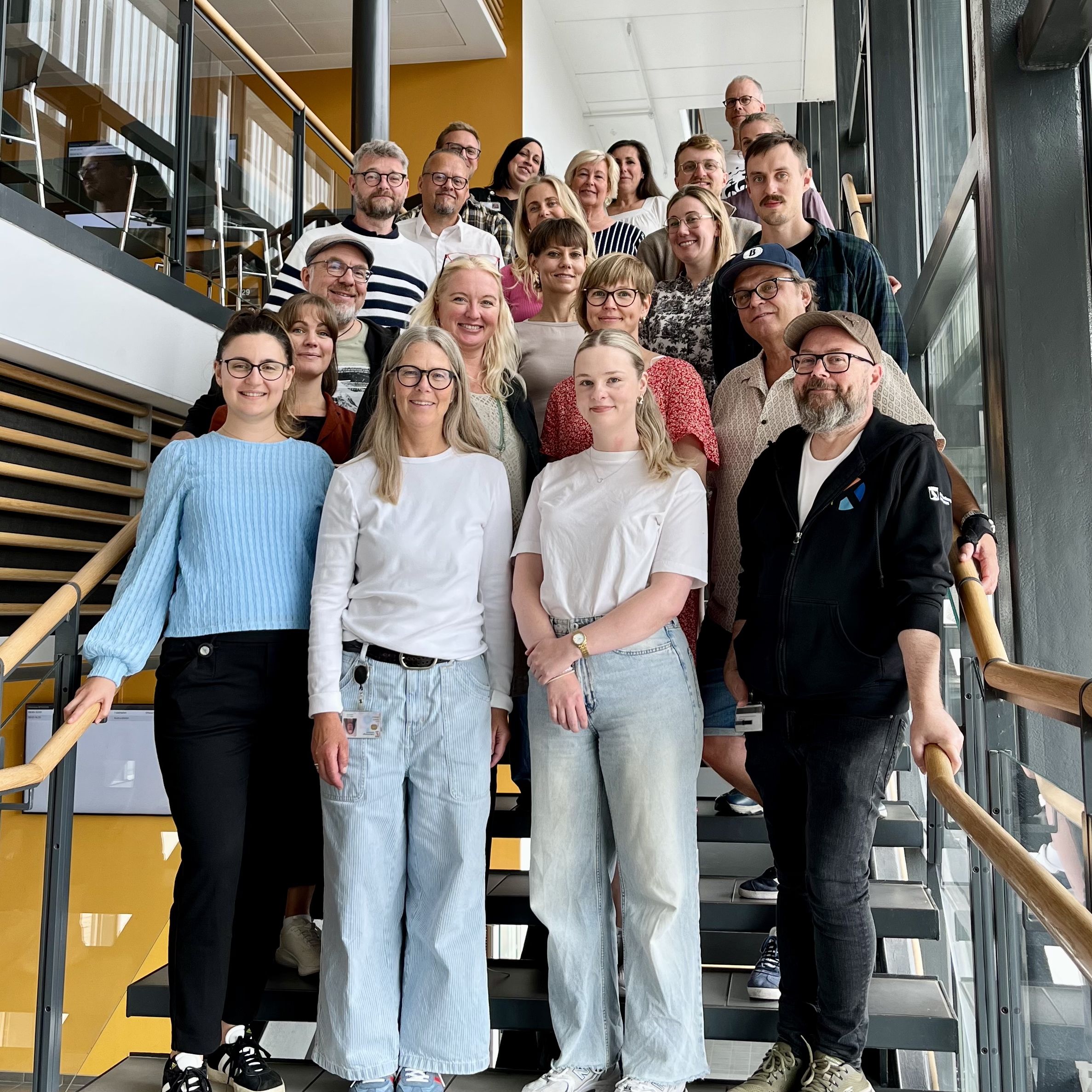 Gruppbild anställda på kulturskolan. De står i en trappa och tittar in i kameran.