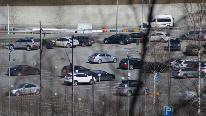 Stor parkeringsplats med många bilar och många tomrum.