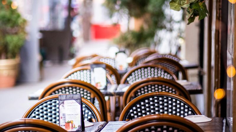 Bord och stolar utomhus, med grönska runt om.