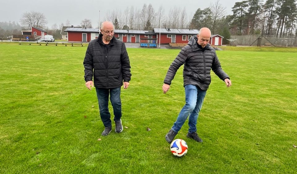 Tommy och Dag lirar med en boll på en perfekt grön plan.