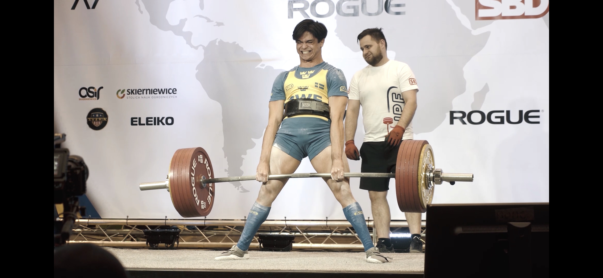 Carl står med spända ben  och håller skivstång med mycket vikt.