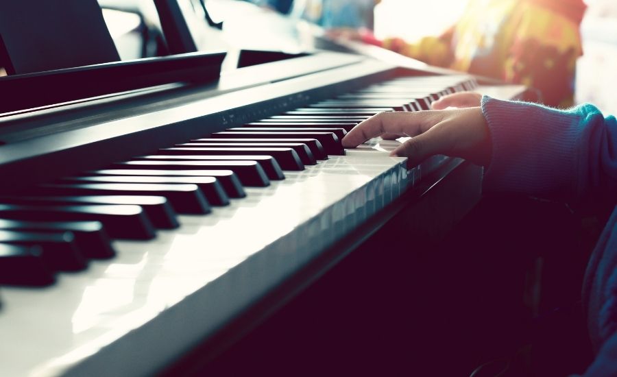 barnhänder som spelar piano