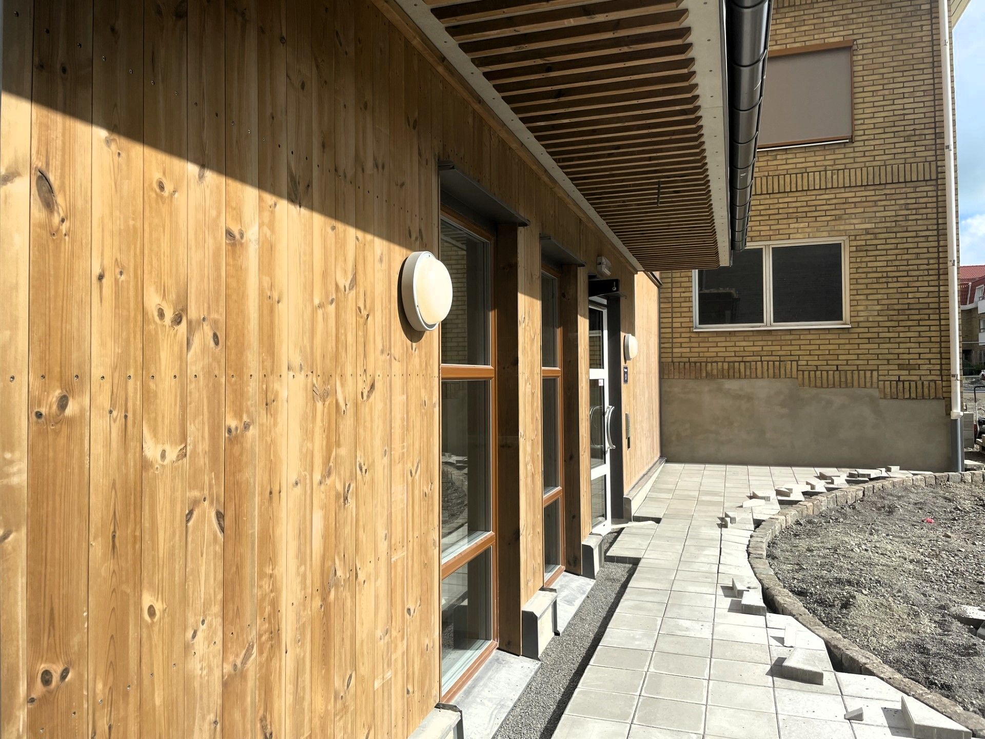 Fasad och  vid huvudentré och plattläggning som börjar bli klar