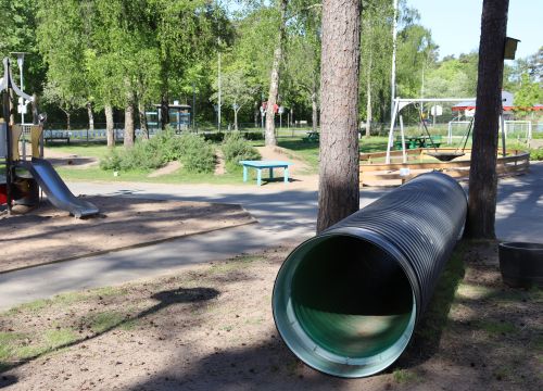 Kryprör i sandlåda, gård i bakgrunden