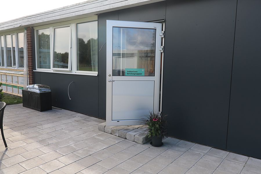 Entrén till en låg, svart byggnad.