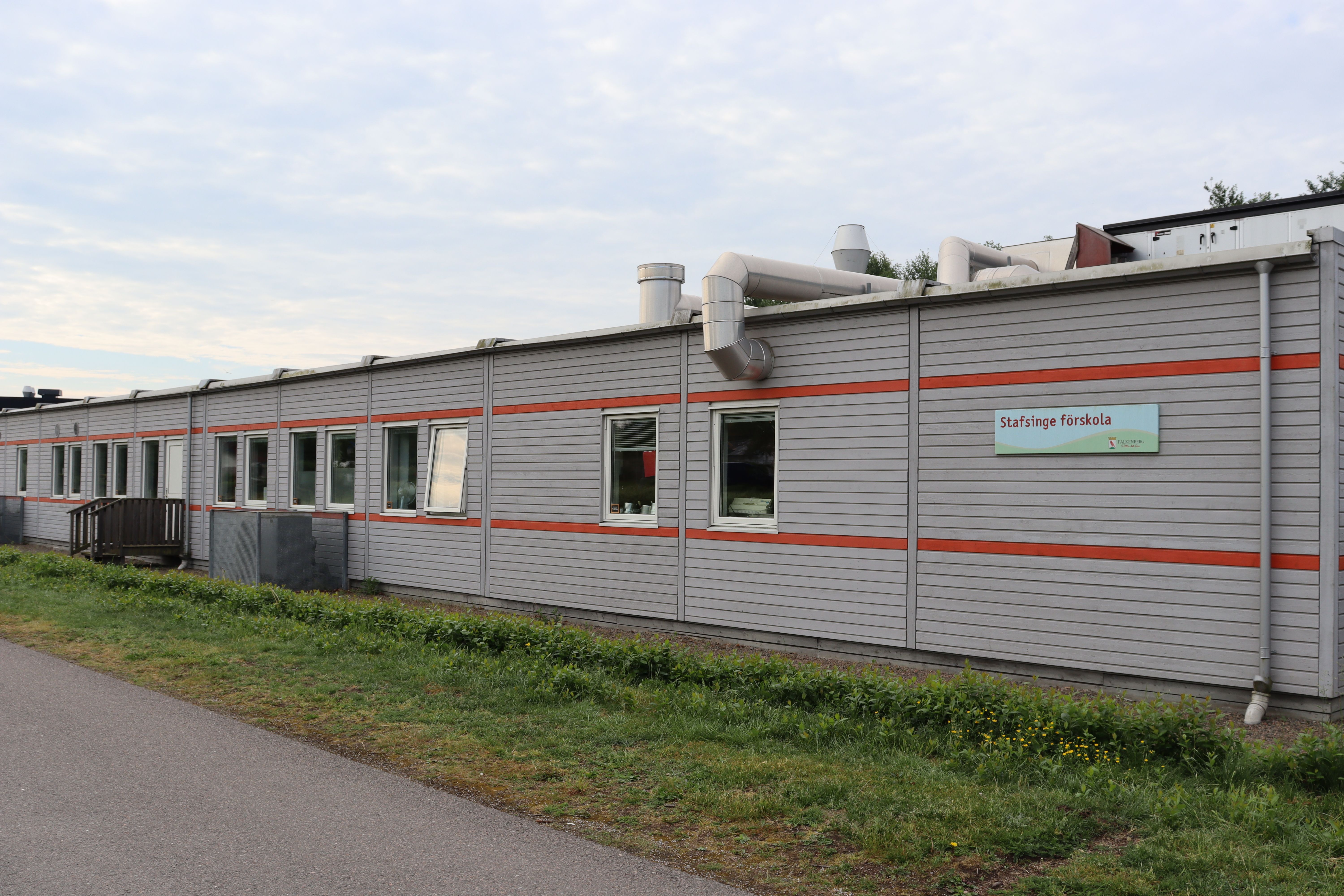Grå låg byggnad med röda ränder