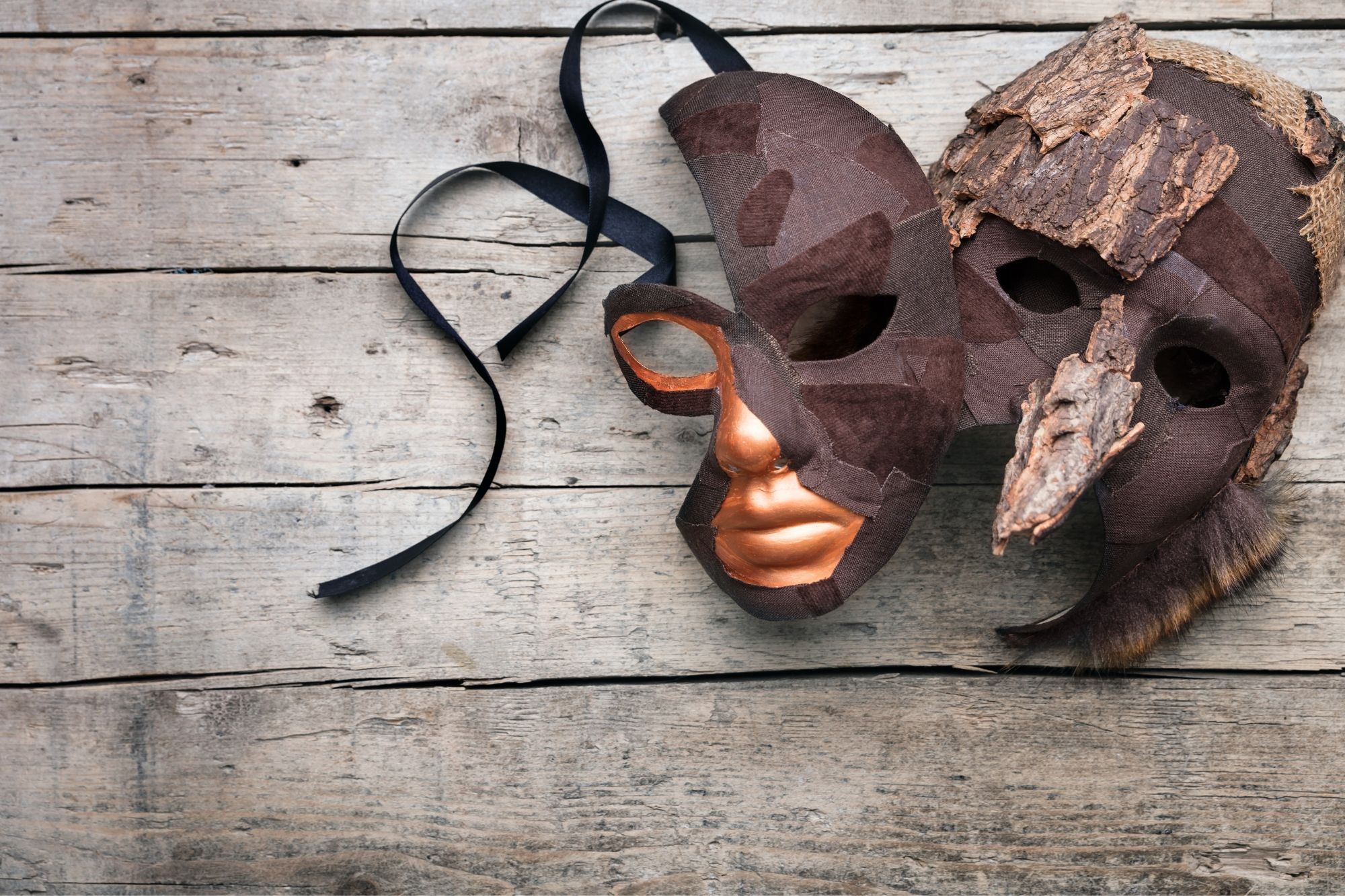 Två teatermasker ligger på ett bord