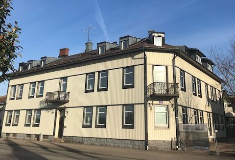 Ett äldre, ljusgult trähus med mörka knutar.