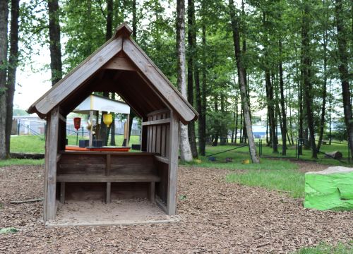 Lekstuga i skog med kiosk bakom