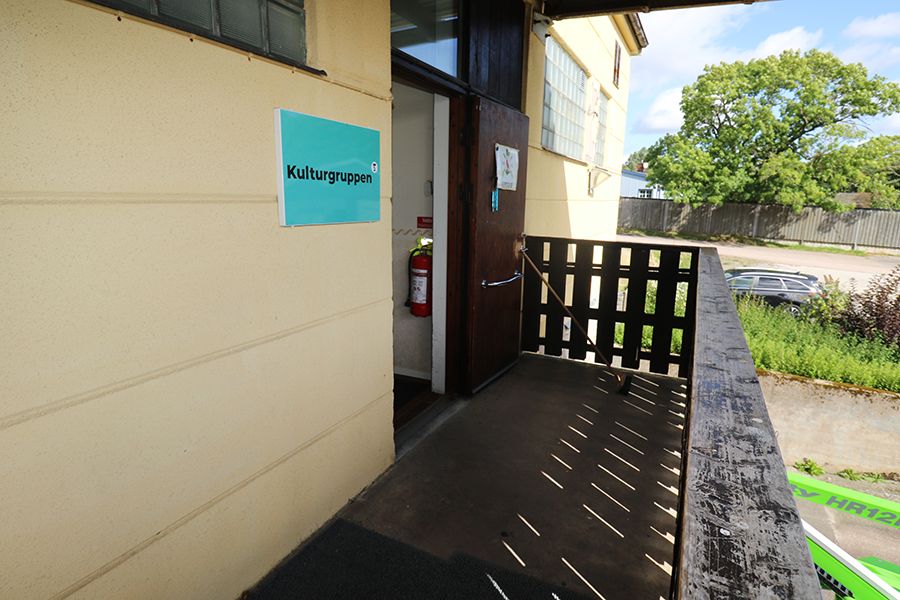 Entrén till en gul byggnad.