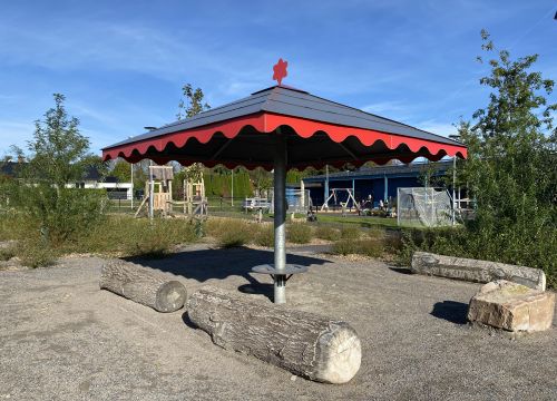 Träställning med vita skynken - grön gård med leksaker i bakgrunden