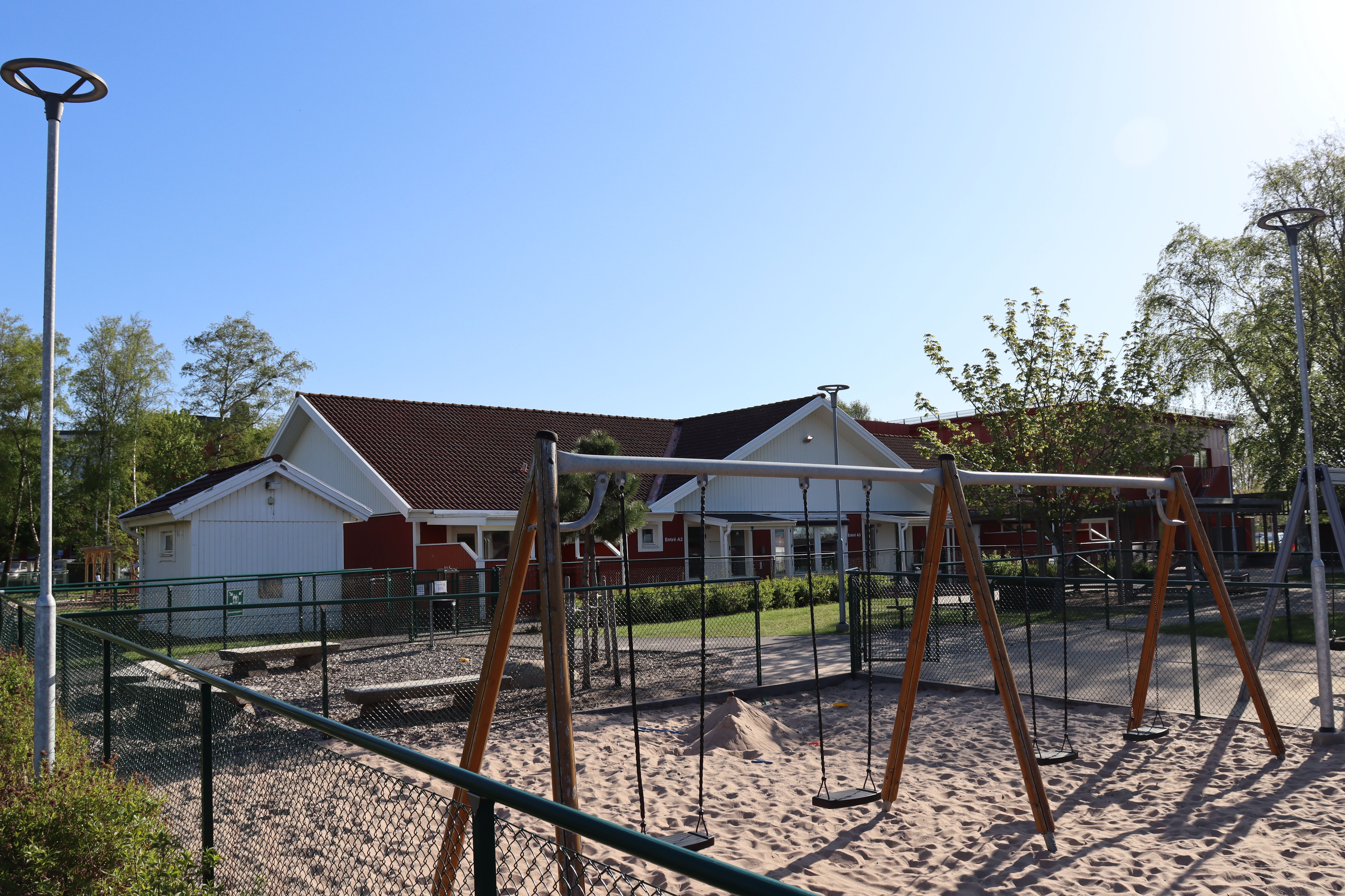 Röd byggnad med parkering framför.