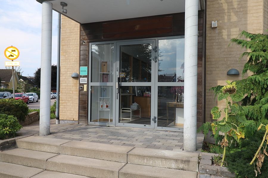 Entrén till en gulbeige tegelbyggnad.