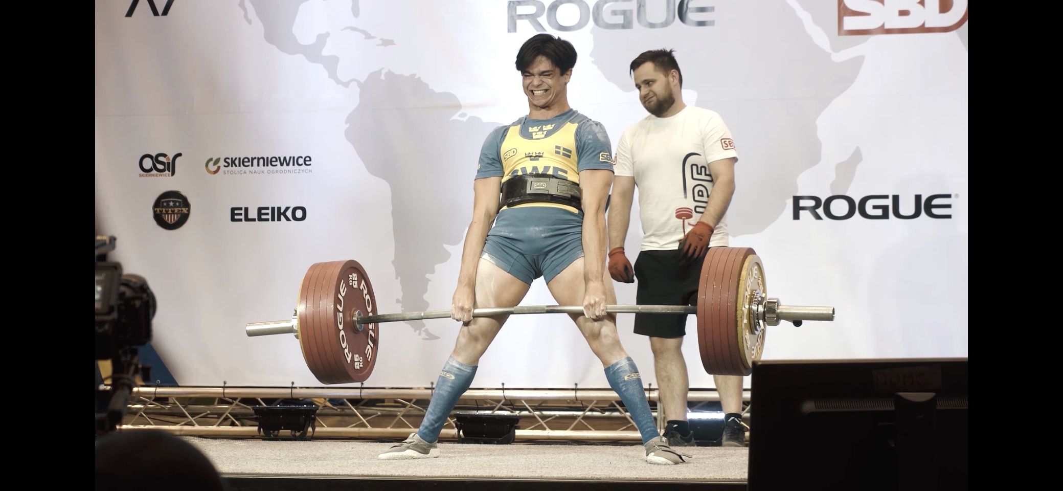 Carl står med spända ben  och håller skivstång med mycket vikt.