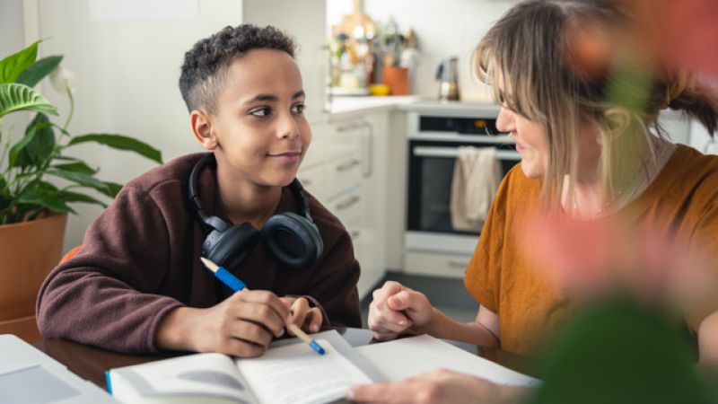 Äldre kvinna spelar kort med person.