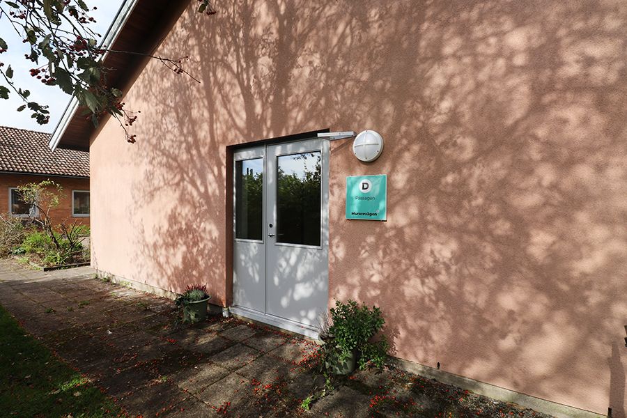 Entrén till en aprikosfärgad byggnad.