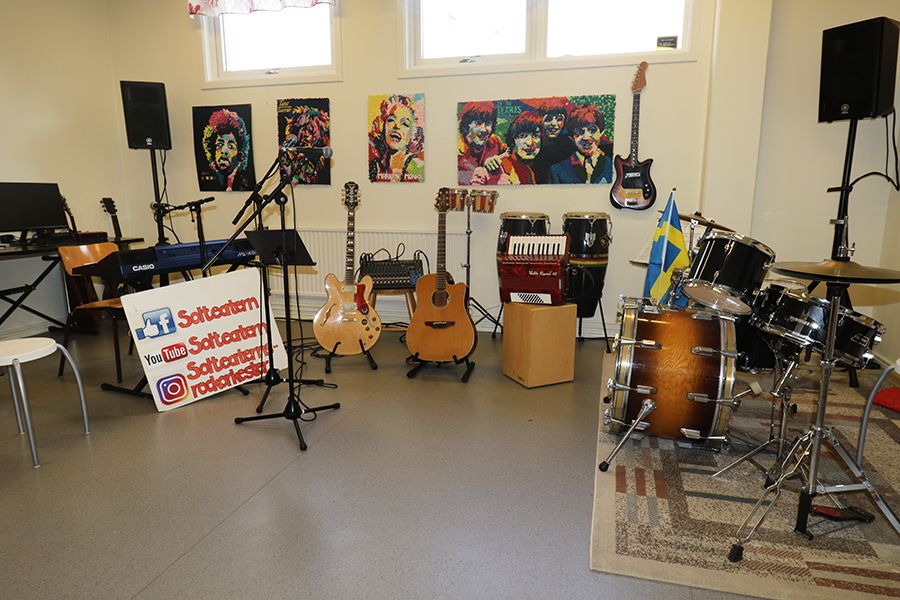 Replokal med musikinstrument. På väggen sitter färgglada tavlor med olika band.