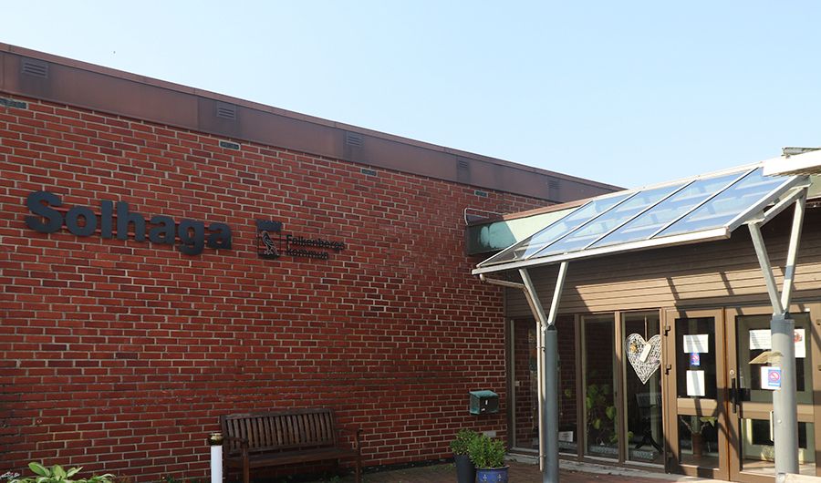 Entrén till en mörkröd tegelbyggnad.