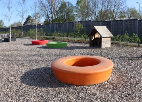 Färgglada sitt- och balansringar med lekstuga i bakgrunden