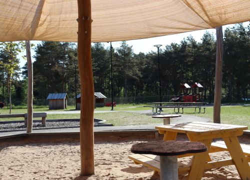 Sandlåda med solskydd - grön gård med klätterställning i bakgrunden