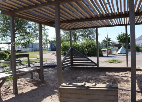 Sandlåda med solskydd - gården i bakgrunden