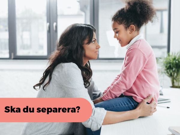 En vuxen kvinna håller om en flicka som sitter på ett bord framför henne.