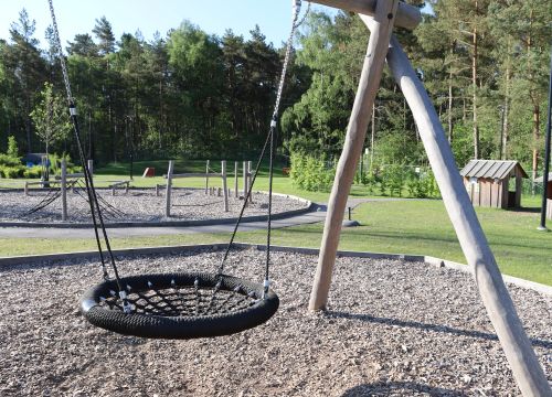 Kompisgunga med balansbana och lekstugor i grön bakgrund
